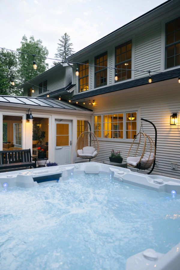 Outdoor hot tub nestled among trees, on the back patio of Mile Away
